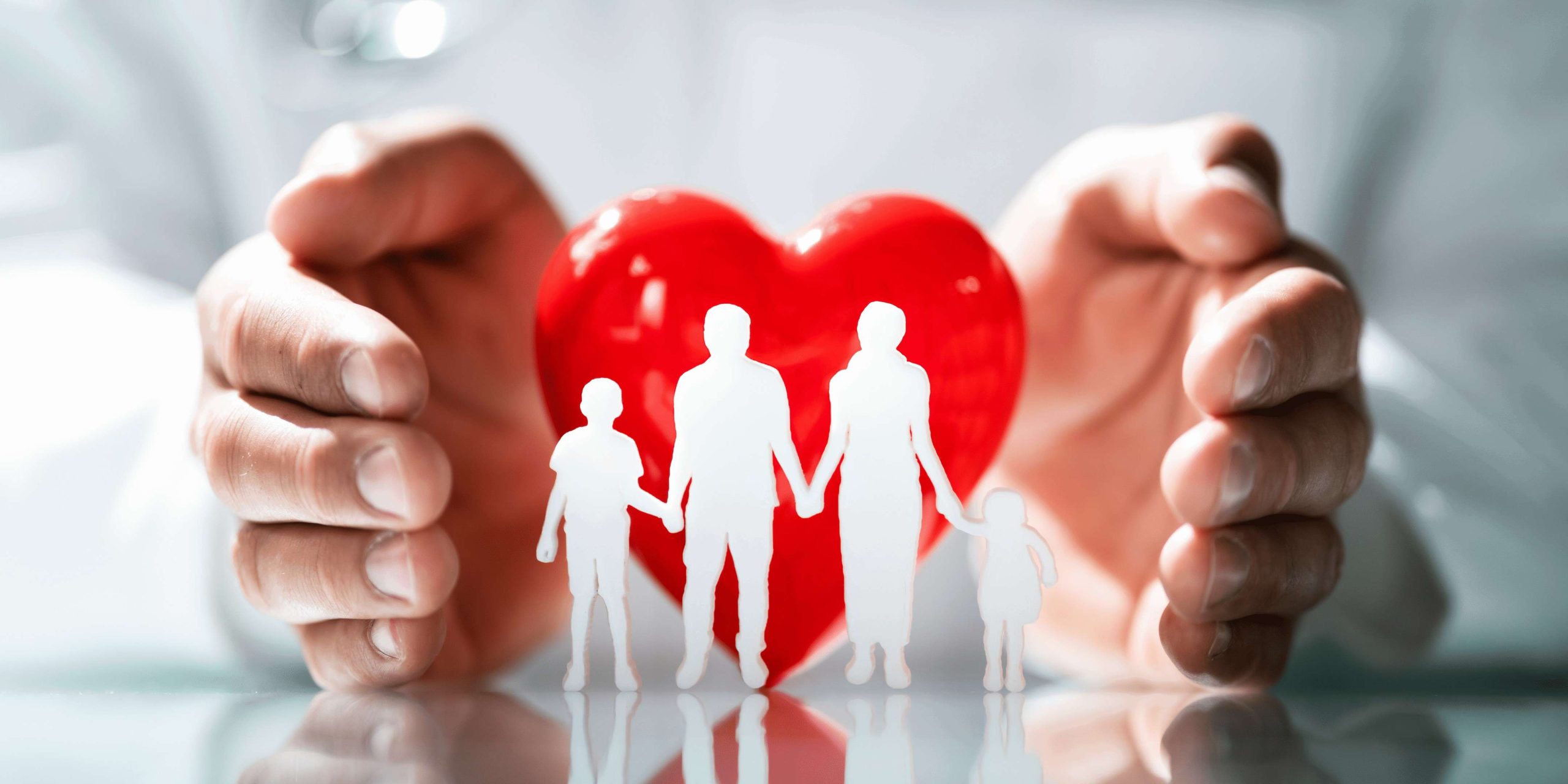 Equidad territorial para cobertura sanitaria universal Manos rodean un corazón rojo tras figuras de familia, reflejando el apoyo Fundación porqueViven